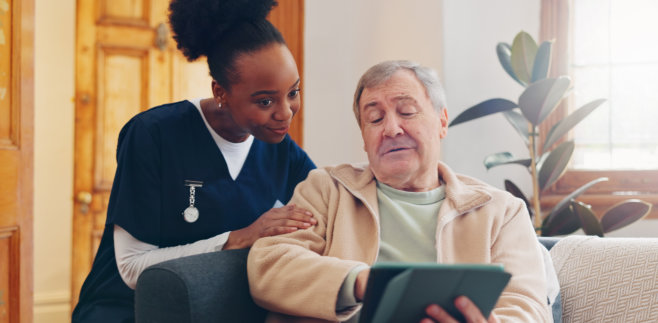 nurse and elderly man looking at the tablet