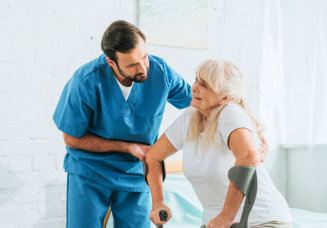 nurse assisting elderly woman to stand