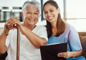 nurse and elderly woman looking at the camera