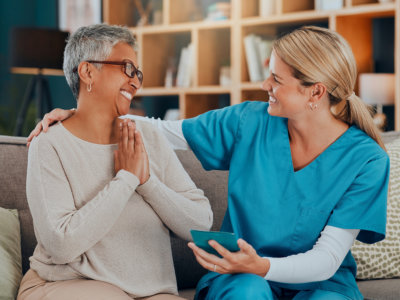 healthcare worker and senior woman smiling at each other