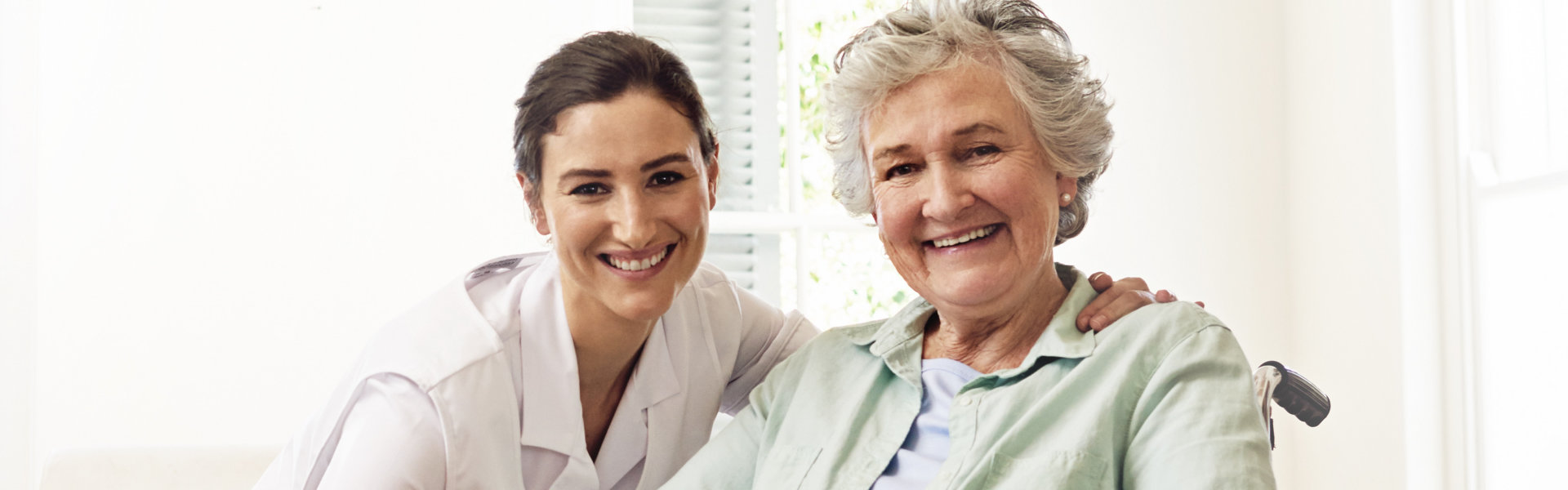 nurse and elderly woman looking at the camera