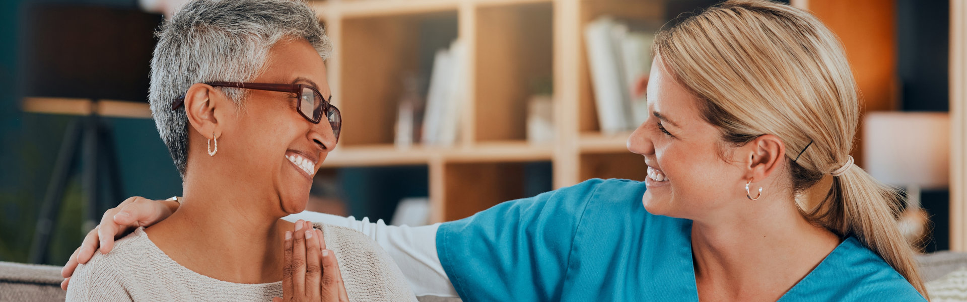 healthcare worker and senior woman smiling at each other